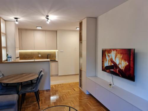cocina y sala de estar con TV en la pared en AGERA Apartments, en Banja Luka