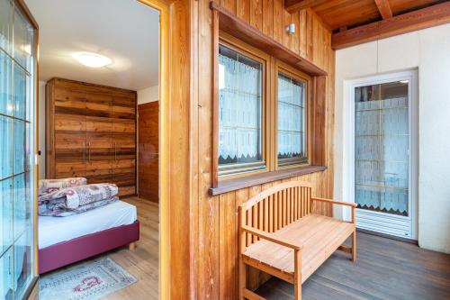 1 dormitorio con 1 cama y pared de madera en Cesa San Florian Appartamento 2 en Canazei