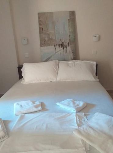 a white bed with two folded towels on it at THSTUDIOS Its the best in Faraí