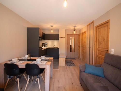Il comprend un salon et une cuisine avec une table et un canapé. dans l'établissement Charmant T2 avec parking à Valmorel - FR-1-291-867, à Valmorel