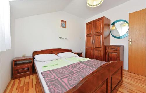 Schlafzimmer mit einem Bett und einem Holzschrank in der Unterkunft Cozy Apartment In Vodice With Kitchen in Vodice