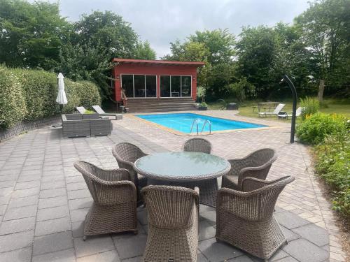 a patio with a table and chairs and a pool at Vingårdens Bed & Breakfast in Helsingborg