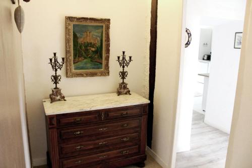 a dresser in a hallway with a painting on the wall at Domaine du Bourdil au pays Cathare in Chalabre