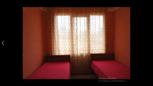 a room with two beds in front of a window at Princ Georgia in Ureki