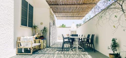 a patio with chairs and a table in a house at Il Mirto Blu in Porto Cesareo