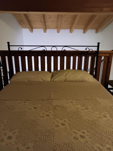 un grande letto con testiera e cuscini in legno di OASI DEL GARDA 2 a Monzambano