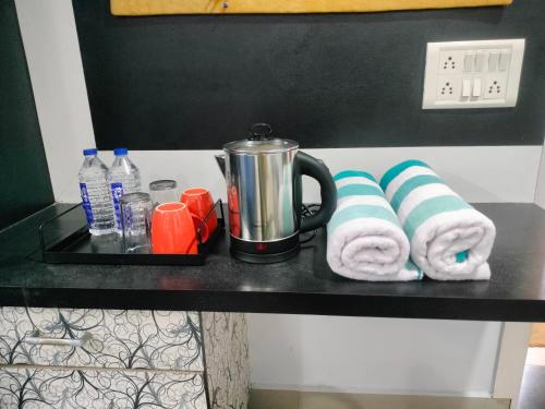 a shelf with towels and a coffee maker on it at Unique Couple Friendly Stay in Morbi
