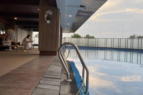 a swimming pool with a handrail next to a building at Stunning 2 Bedroom Apartment in Yogyakarta