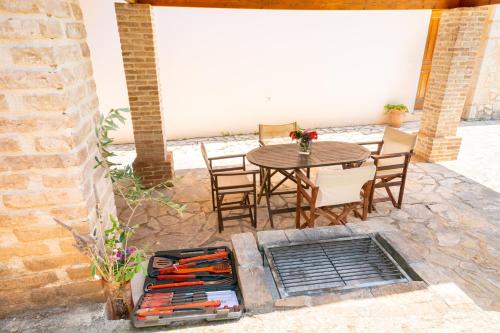 a patio with a table and chairs and a grill at Villa Apollo up to 8px, private pool in Fiskardho