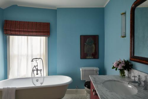 a blue bathroom with a tub and a sink at The Bear Inn, Hodnet in Market Drayton