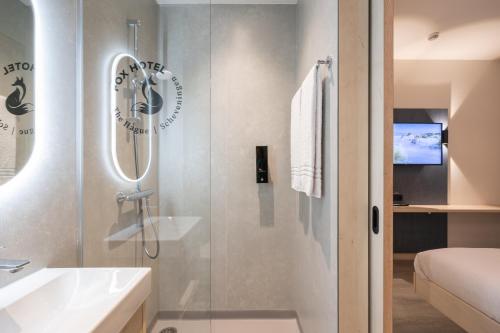 uma casa de banho com um chuveiro e um lavatório. em Fox Hotel The Hague Scheveningen em Scheveningen