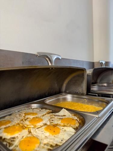 two pans of eggs are cooking in a kitchen at Hotel Theresia in Kolín