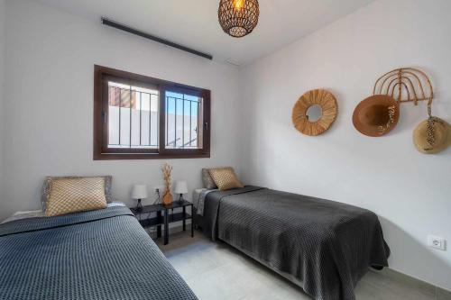 1 Schlafzimmer mit 2 Betten und einem Fenster in der Unterkunft Casa Mira aparamento con jardín y piscina comuni in San Juan de los Terreros