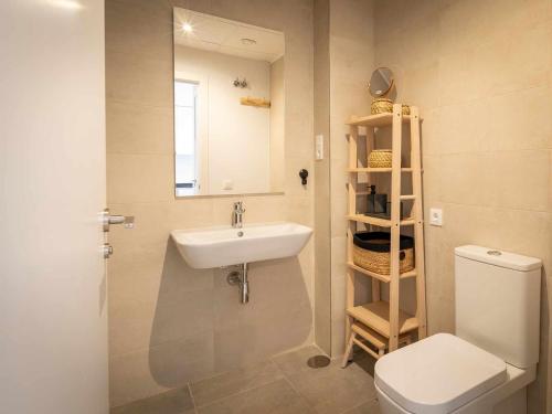 ein Badezimmer mit einem Waschbecken, einem WC und einem Spiegel in der Unterkunft Casa Mira aparamento con jardín y piscina comuni in San Juan de los Terreros
