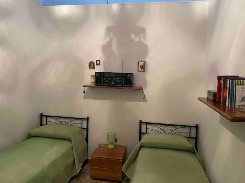 een slaapkamer met 2 bedden en een radio aan de muur bij Girasole in Trepuzzi