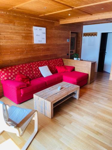 a living room with a red couch and a coffee table at Haus Jomeity in Sillian