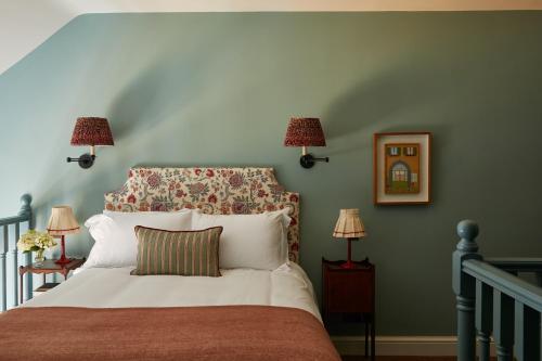 a bedroom with a bed with a headboard and two lamps at The Bear Inn, Hodnet in Market Drayton