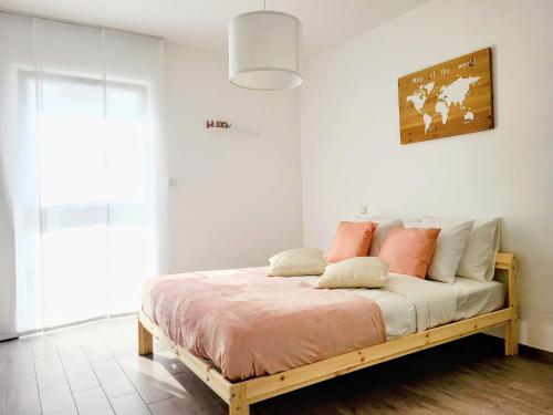 1 dormitorio con 1 cama con almohadas rosas y blancas en Calm and modern apartment, en Eischen