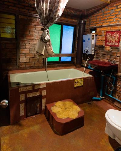 a bathroom with a bath tub and a toilet at Good Life Dacha Wellness Homestay in Pai