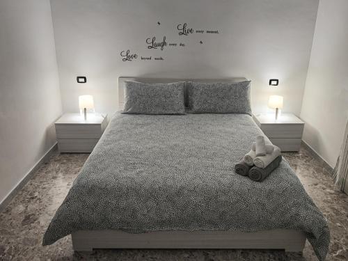 a bedroom with a bed with two lamps and a pair of shoes at Villa Turicchio in Taranto