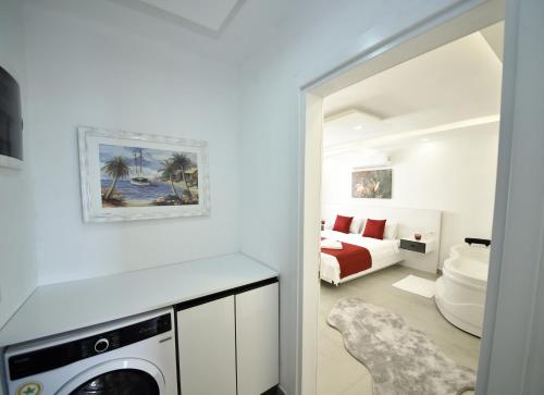 a white bedroom with a bed and a washing machine at Mayda Suit Aparts in Kas