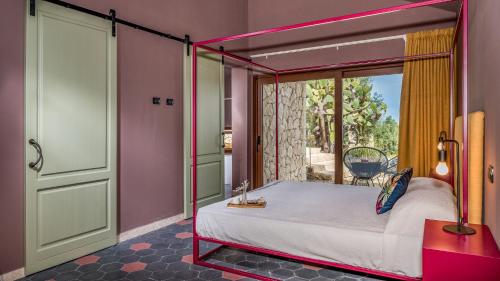 a bedroom with a canopy bed and a balcony at VILLA SUMAC 6, Emma Villas in Sortino