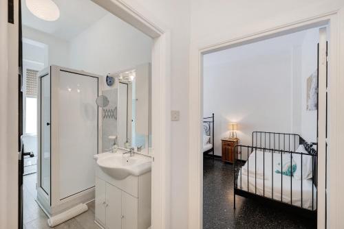 a white bathroom with a sink and a crib at Liguria Home in Vado Ligure
