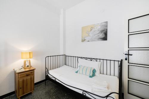 a small bedroom with a bed and a lamp on a night stand at Liguria Home in Vado Ligure