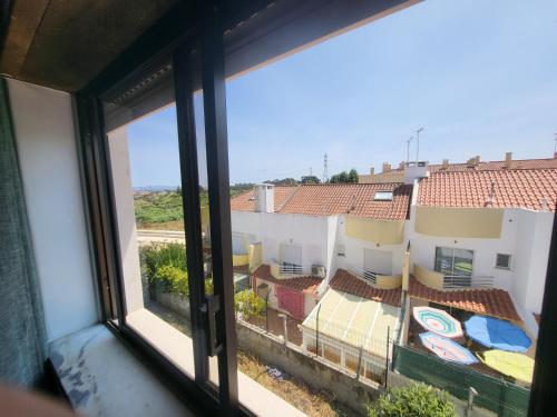 uma vista a partir de uma janela de um edifício com telhados em Margem Sul rooms em Costa de Caparica