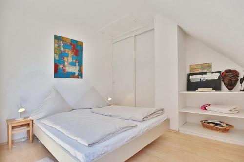 a white bedroom with a bed and a tv at Haus Kastanienallee 3 Haus Kastanienallee 3 Appartement 8 in Timmendorfer Strand
