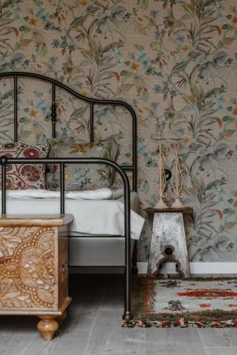 a bedroom with a bed with a floral wallpaper at Folwark Rafałówka by Noclegi Renters in Zabłudów