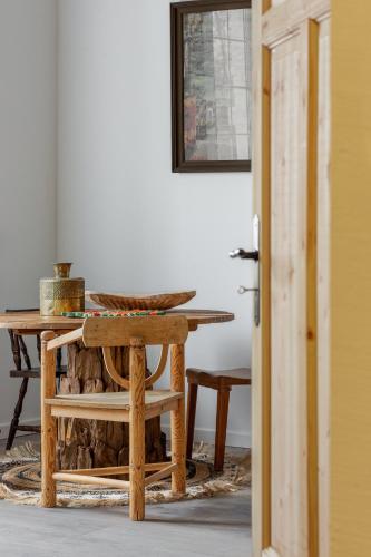 a wooden table with a wooden chair next to a table at Folwark Rafałówka by Noclegi Renters in Zabłudów