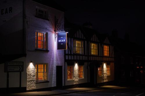 un bâtiment avec un panneau sur son côté la nuit dans l'établissement The Bear Inn, Hodnet, à Market Drayton