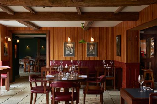 um restaurante com paredes e mesas e cadeiras de madeira em The Bear Inn, Hodnet em Market Drayton