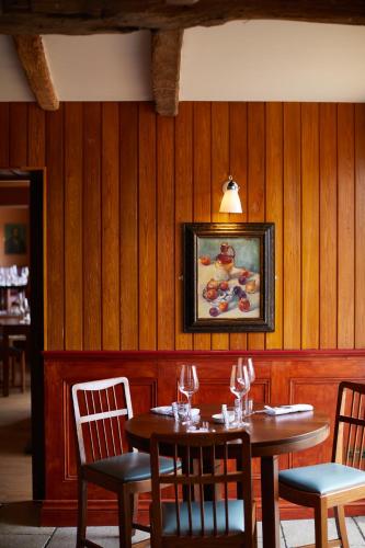 a dining room with two wooden tables and chairs at The Bear Inn, Hodnet in Market Drayton