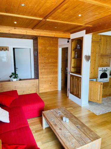 a living room with a red couch and a table at Haus Jomeity in Sillian