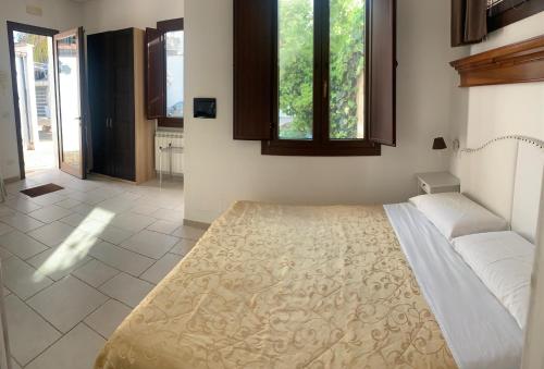 Un dormitorio con una cama grande y una ventana en CORTE CARAFA "un'Oasi nel Centro Storico con parcheggio interno riservato" en Nardò