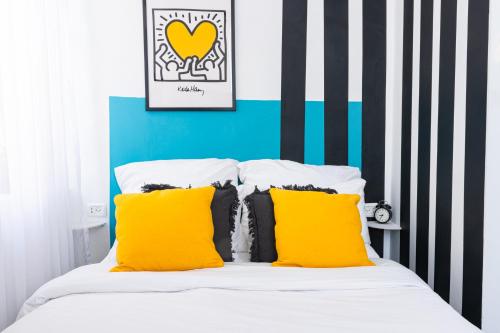 a bedroom with a bed with yellow pillows at Mamilla View- Suites & Apt Hotel in Jerusalem