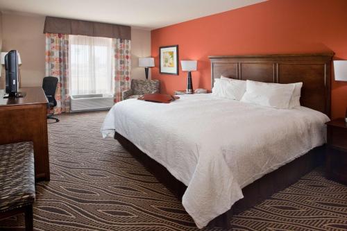 ブライズビルにあるHampton Inn Blythevilleの大きなベッドとデスクが備わるホテルルームです。