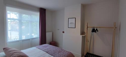 a bedroom with a bed and a window at Maison Rose Plopsaland in De Panne