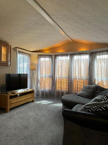 sala de estar con sofá y TV de pantalla plana en Static Caravan - Plymouth - Costal Location en Plymouth