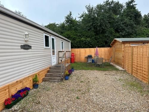 a backyard with a house and a fence at Static Caravan - Plymouth - Costal Location in Plymouth
