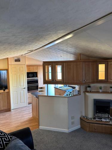 cocina con armarios de madera y chimenea en Static Caravan - Plymouth - Costal Location en Plymouth