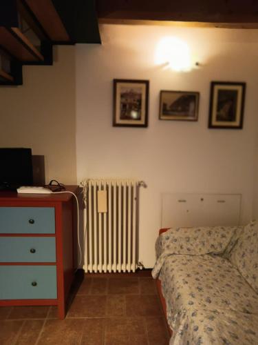 ein Schlafzimmer mit einem Bett, einer Kommode und einem Heizkörper in der Unterkunft OASI DEL GARDA 3 in Monzambano