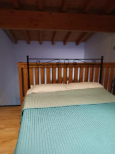 ein Schlafzimmer mit einem Holzbett mit einer grünen Decke in der Unterkunft OASI DEL GARDA 3 in Monzambano