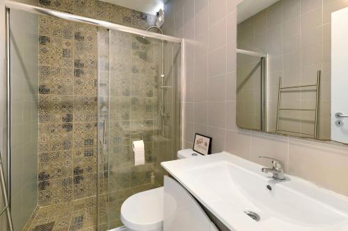 een badkamer met een wastafel, een douche en een toilet bij Zen Village Azul in Fernao Ferro