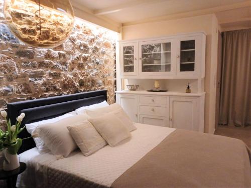 a bedroom with a bed with white pillows at Angel's Suites in Samos