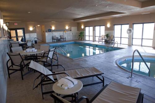 un hotel con piscina, mesas y sillas en Hampton Inn Colby, en Colby