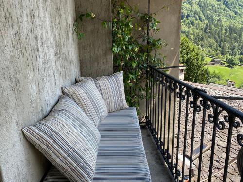 een bank met kussens op een balkon bij Dagli Olivari - Casa Ale in Gromo