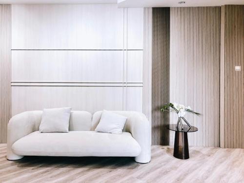 uma sala de estar com um sofá branco e uma mesa em Rest Bugis Hotel em Singapura